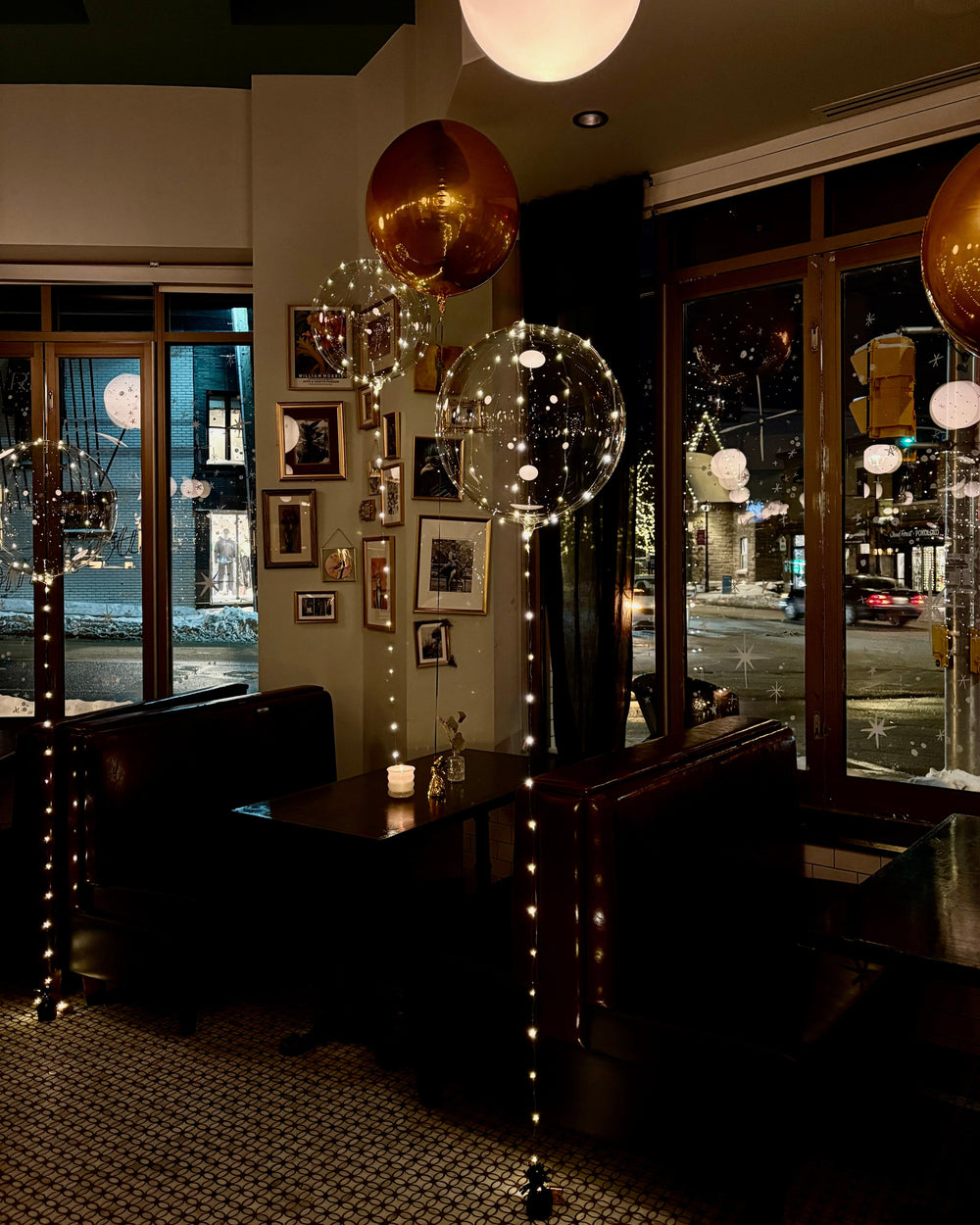Modern interior at night with decorative gold spherical orbz balloons and string lights over clear balloons  in a stylish room.