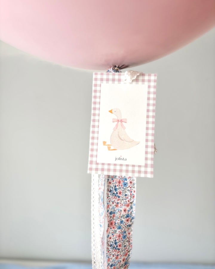 close-up of a card with a sitting goose and the fabric tassel
