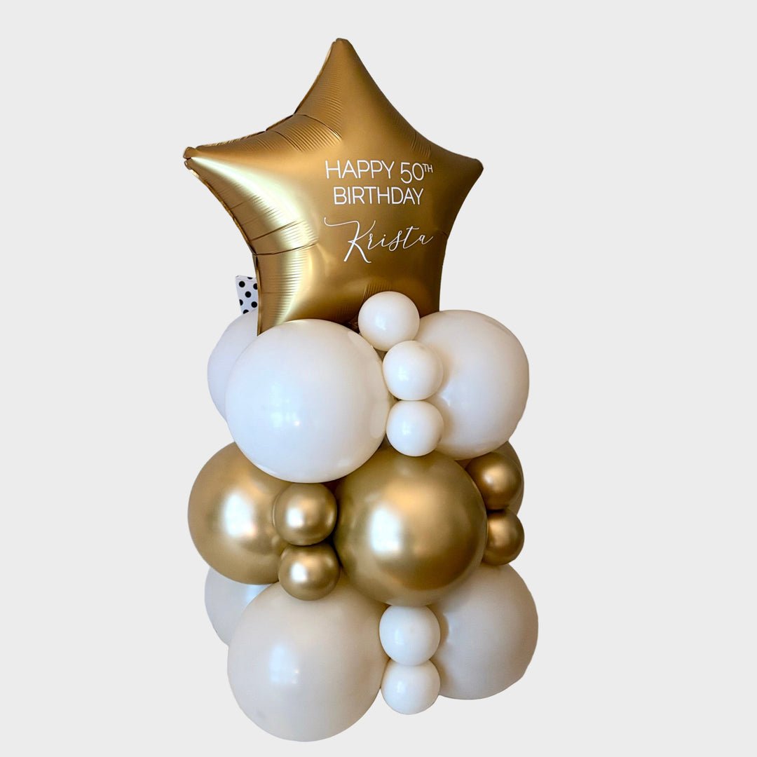 Decorative balloon arrangement with a gold star balloon with custom text and white and gold balloon base