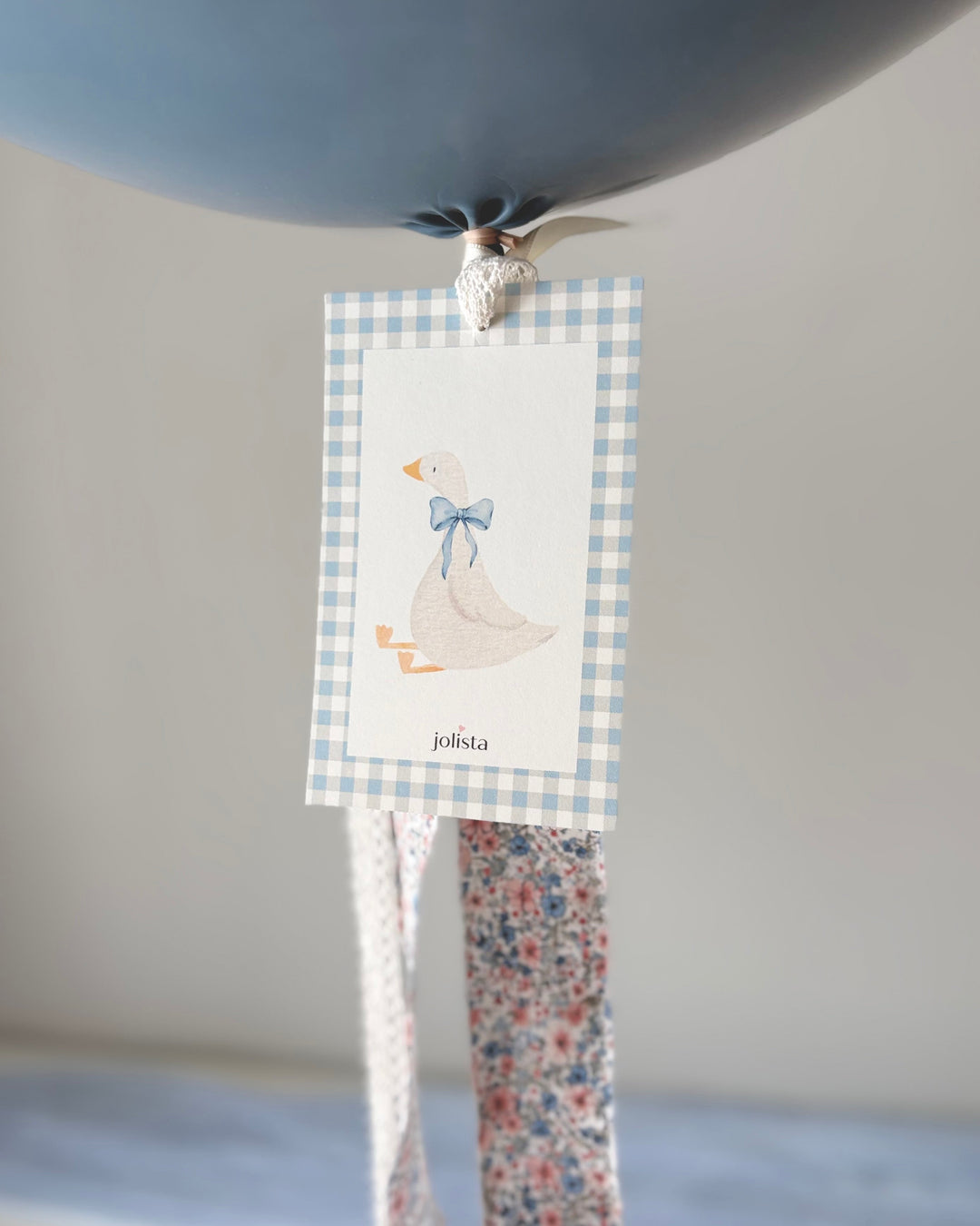 close up of a card with a silly goose with a blue bow  and the fabric tassel