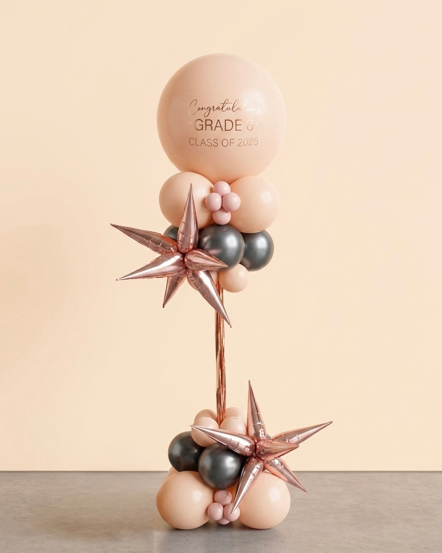 pink balloon balloon column with pink jumbo balloon on top and star-shaped accents