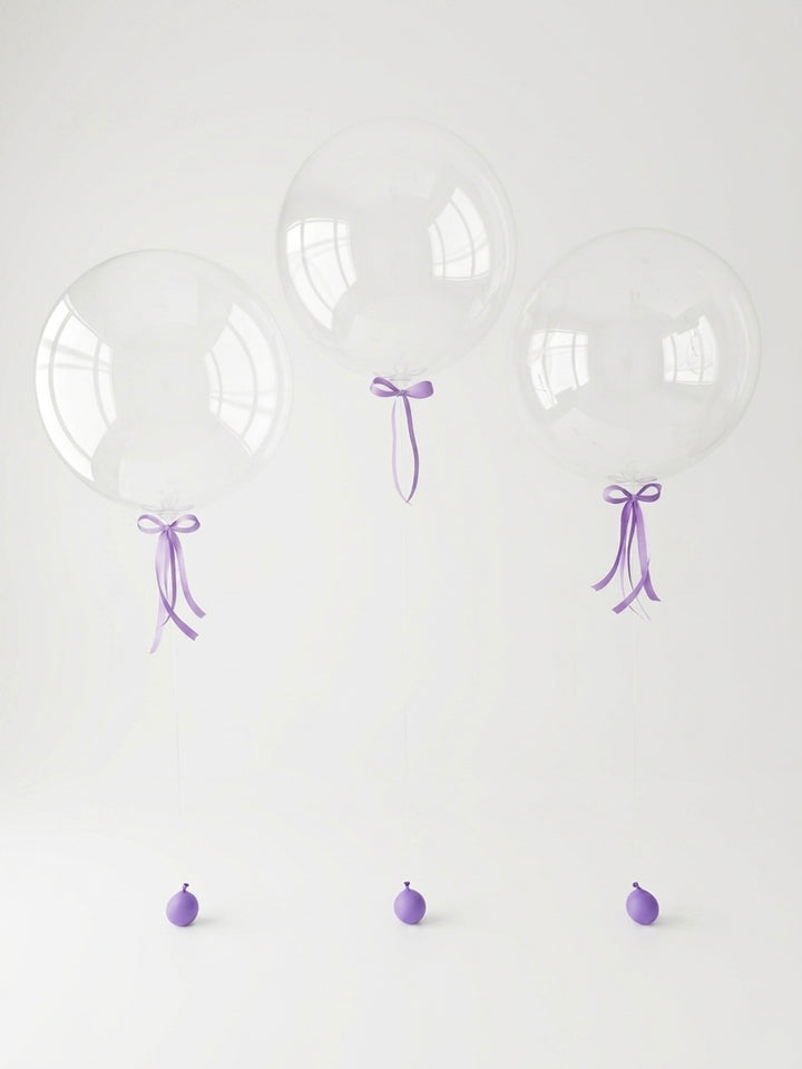 set of three clear bubble balloons with lilac satin bows and transparent line, with lilac balloon weights