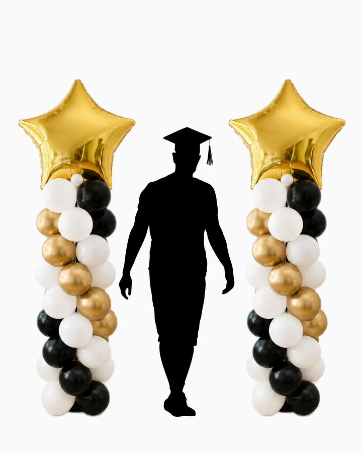 Two gold, black, and white balloon columns topped with gold star foil balloons, flanking a black silhouette of a graduation cap and gown on a plain white background to show height of columns