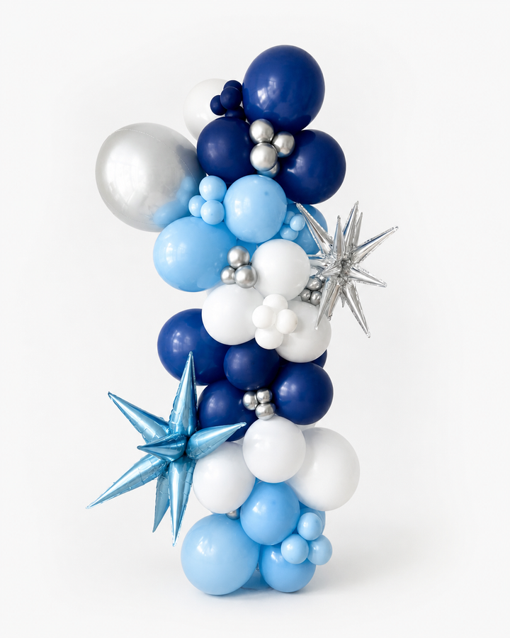 organic Balloon columnwith blue, white, and silver balloons and star shaped accent balloons on a white background