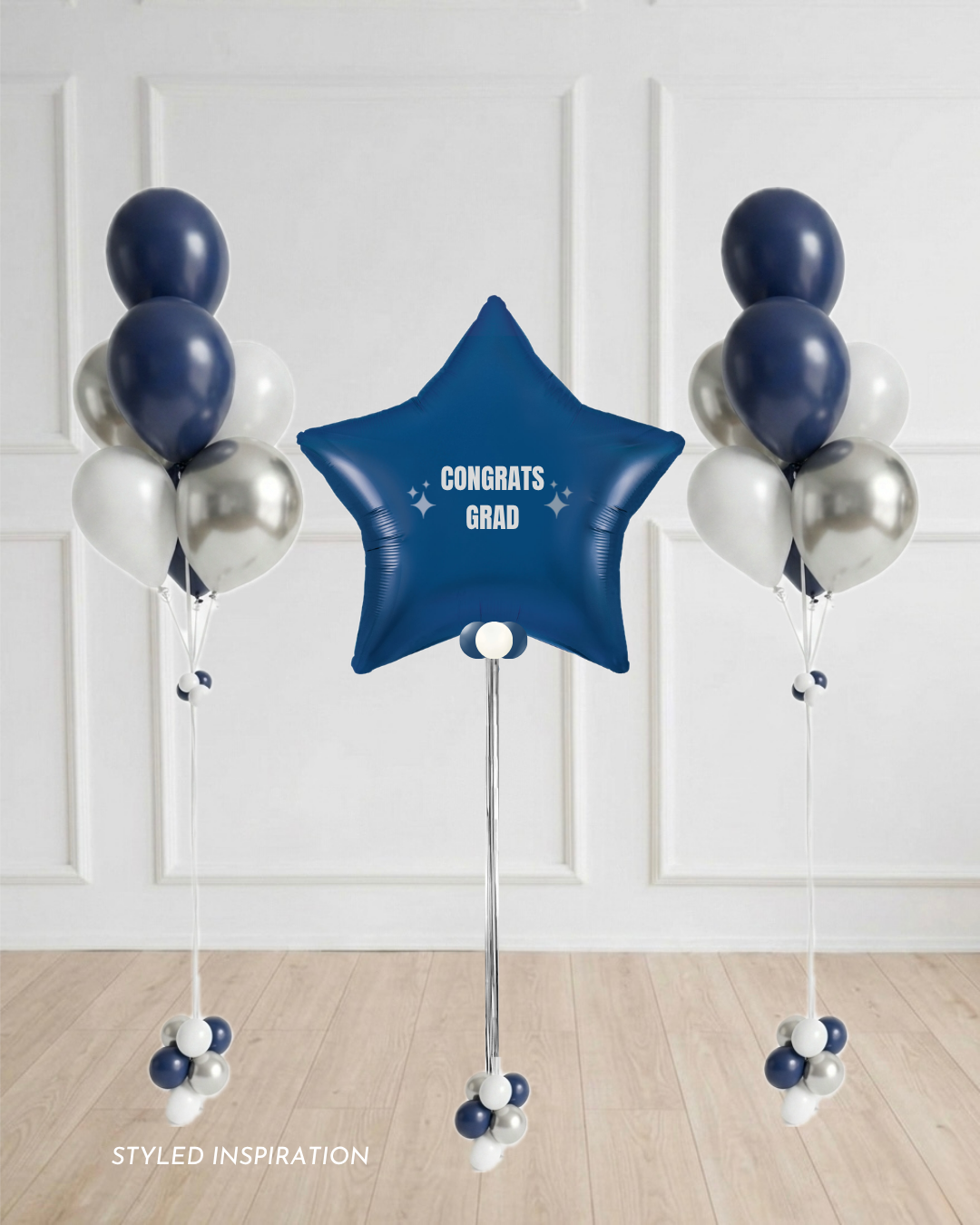 navy star balloon with  text "Congrats Grad" surrounded by balloon bouquets in navy blue, white, and silver.