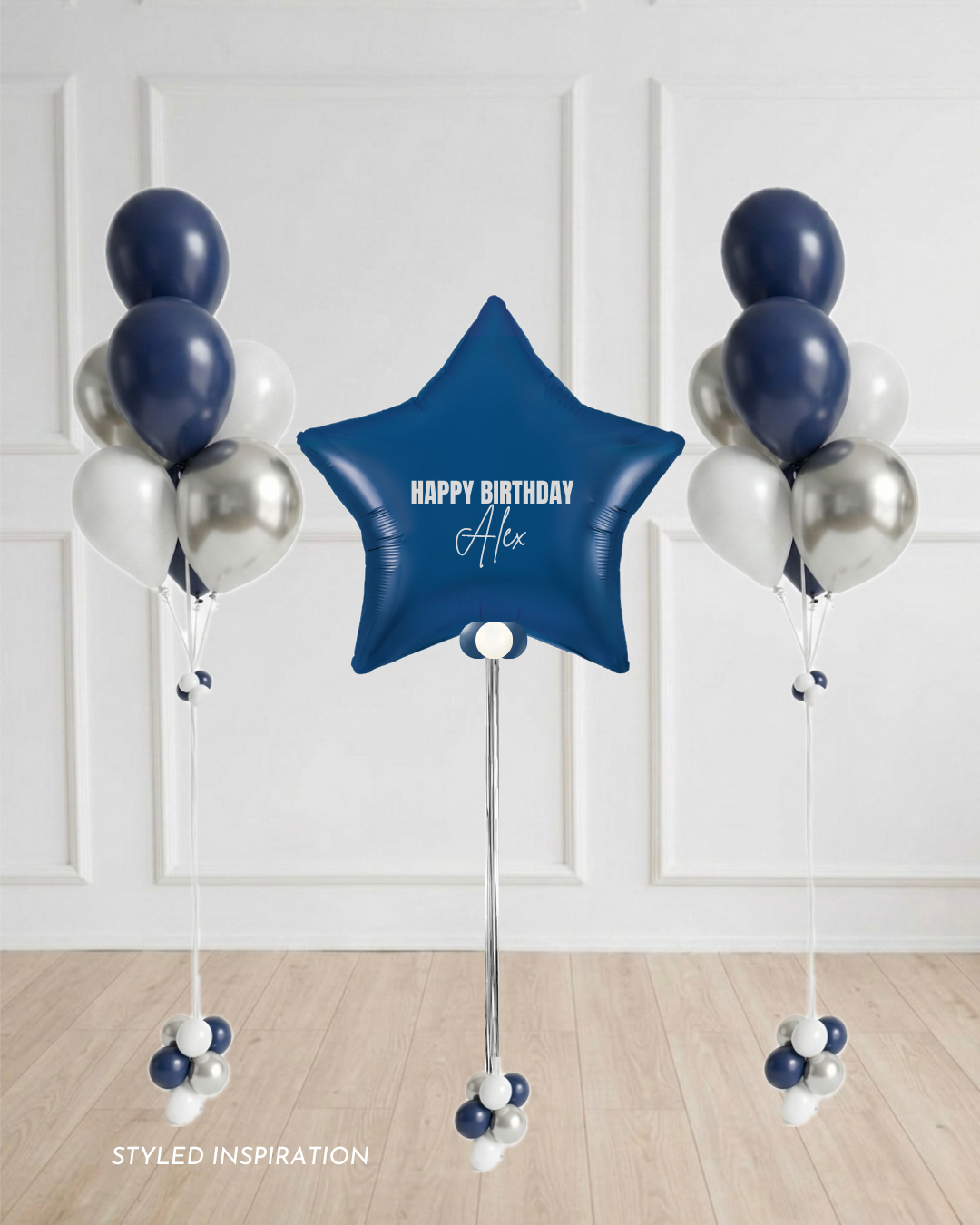 navy star balloon with custom text surrounded by two blue, white, and silver balloon bouquets