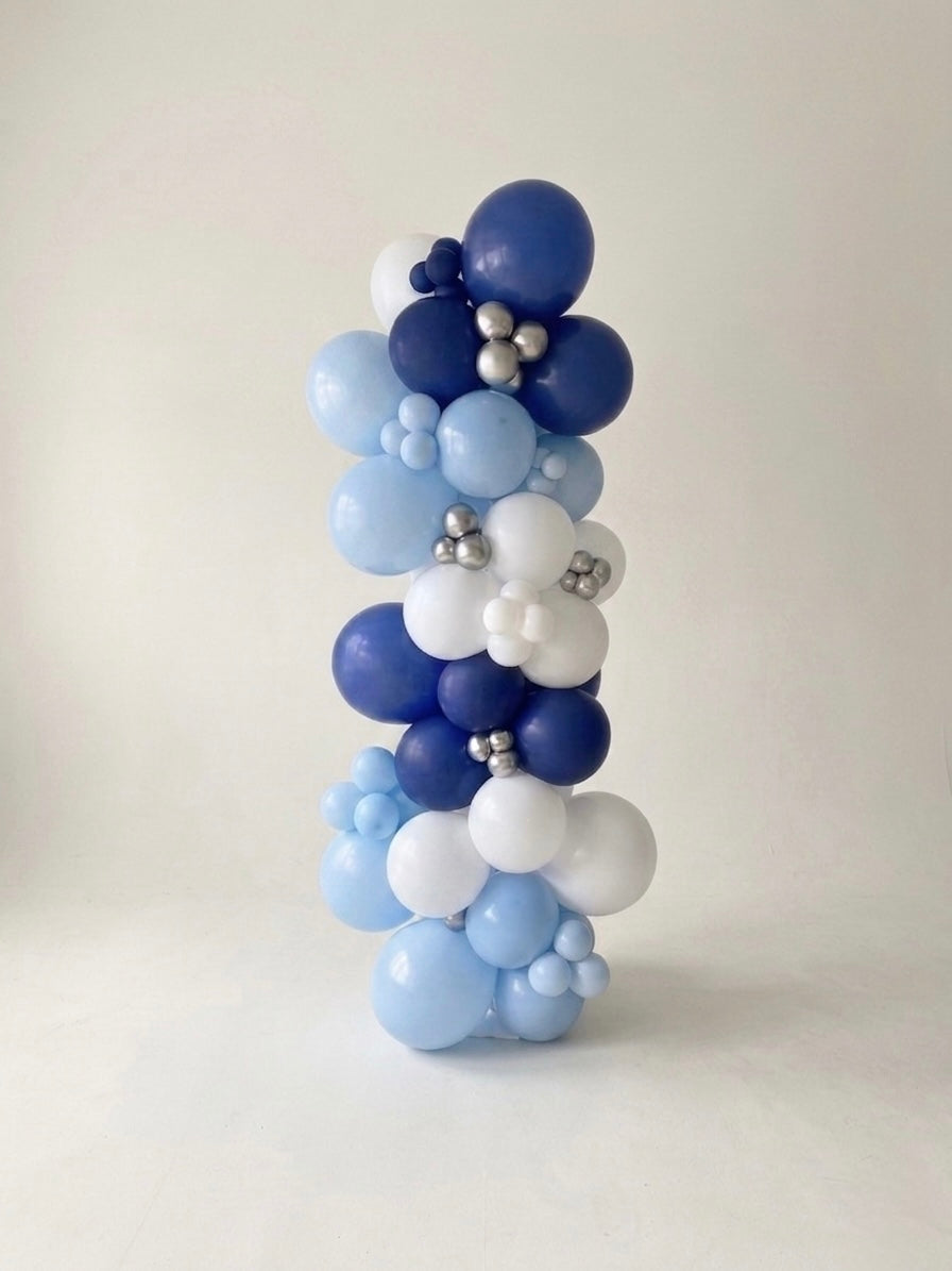 organic balloon column arrangement with metallic mini balloon accents studio setting with plain soft white photographer backdrop