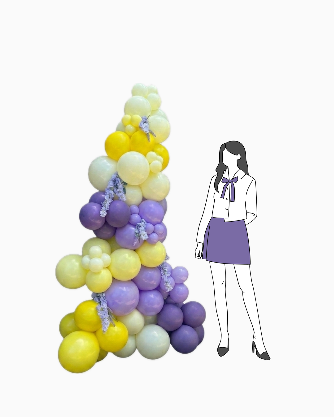 person figure standing next to freestanding organic balloon garland