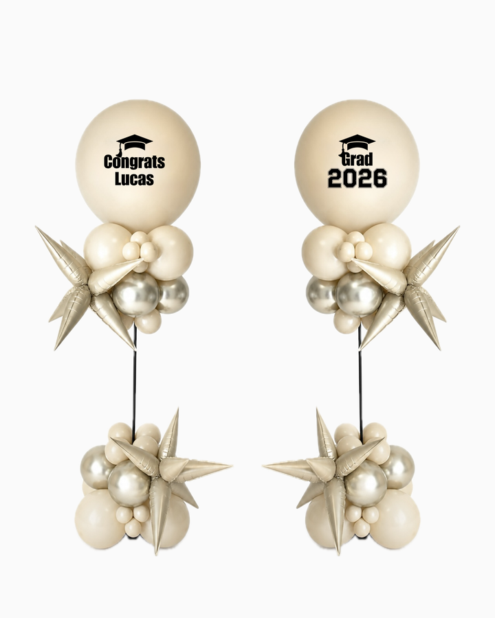 Graduation-themed balloon columns with personalized text and starburst balloon accents on a white background