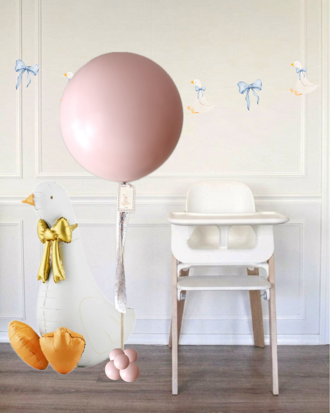 pink jumbo balloon next to a white high chair and a sitting goose balloon in a room